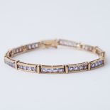 A 9ct yellow gold bracelet set with round cut tanzanite's, length 18-18.5cm, push in clasp &