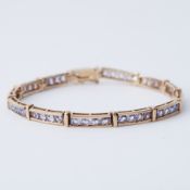 A 9ct yellow gold bracelet set with round cut tanzanite's, length 18-18.5cm, push in clasp &