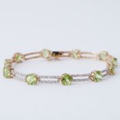 A 9ct yellow gold bracelet set with round cut peridot interspaced with rectangular links set with