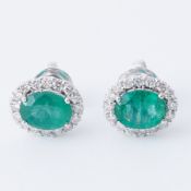 A pair of 18ct white gold earrings set with a central oval cut emerald, approx. total emerald weight