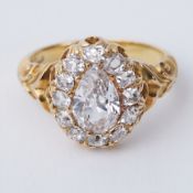 An antique 18ct yellow gold ring set with a central old pear cut diamond, measuring