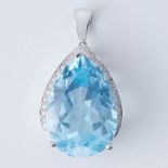 An 18ct white gold pendant set with a pear cut blue topaz, approx. 23.85 carats, surrounded by small