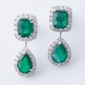 A pair of 18ct white gold drop earrings set with emerald cut & pear shaped emeralds and surrounded