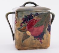 William Moorcroft early 'Pomegranate green ground twin handled Biscuit jar with replacement lid,