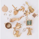 A quantity of 9ct yellow gold charms to include a guitar, dice, fish with pearl, heart, anchor &