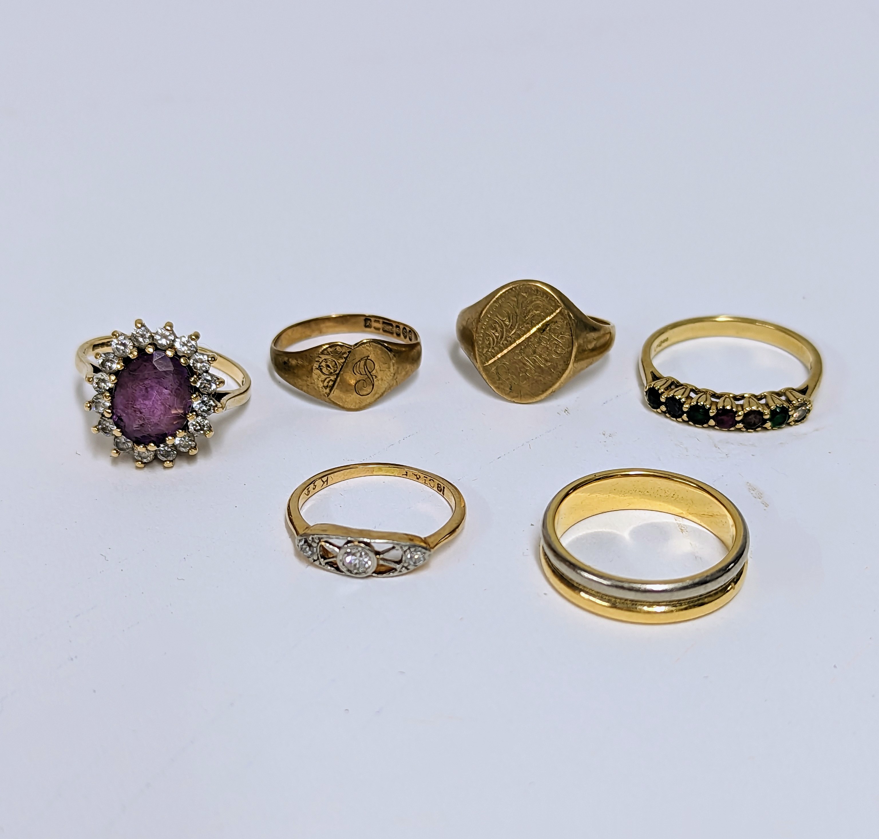 Six rings to include a 9ct yellow gold oval signet ring, a 9ct yellow gold cluster ring set