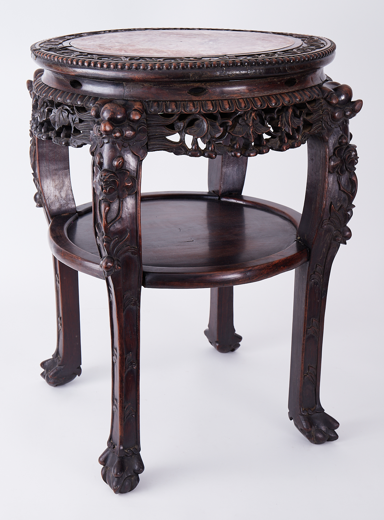 A Chinese carved hardwood low table inset with pink marble and lower tier, height 67cm.