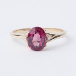 A 9ct yellow gold ring set with a 2.45 carat Comeria Garnet (pink purple hues) set to each side