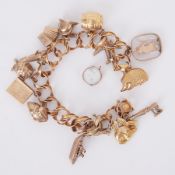 A 9ct yellow gold charm bracelet with fifteen charms (one loose), all hallmarked apart from the