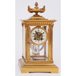 A brass cased four glass clock with eight day movement striking on a gong with pendulum and key,