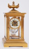 A brass cased four glass clock with eight day movement striking on a gong with pendulum and key,