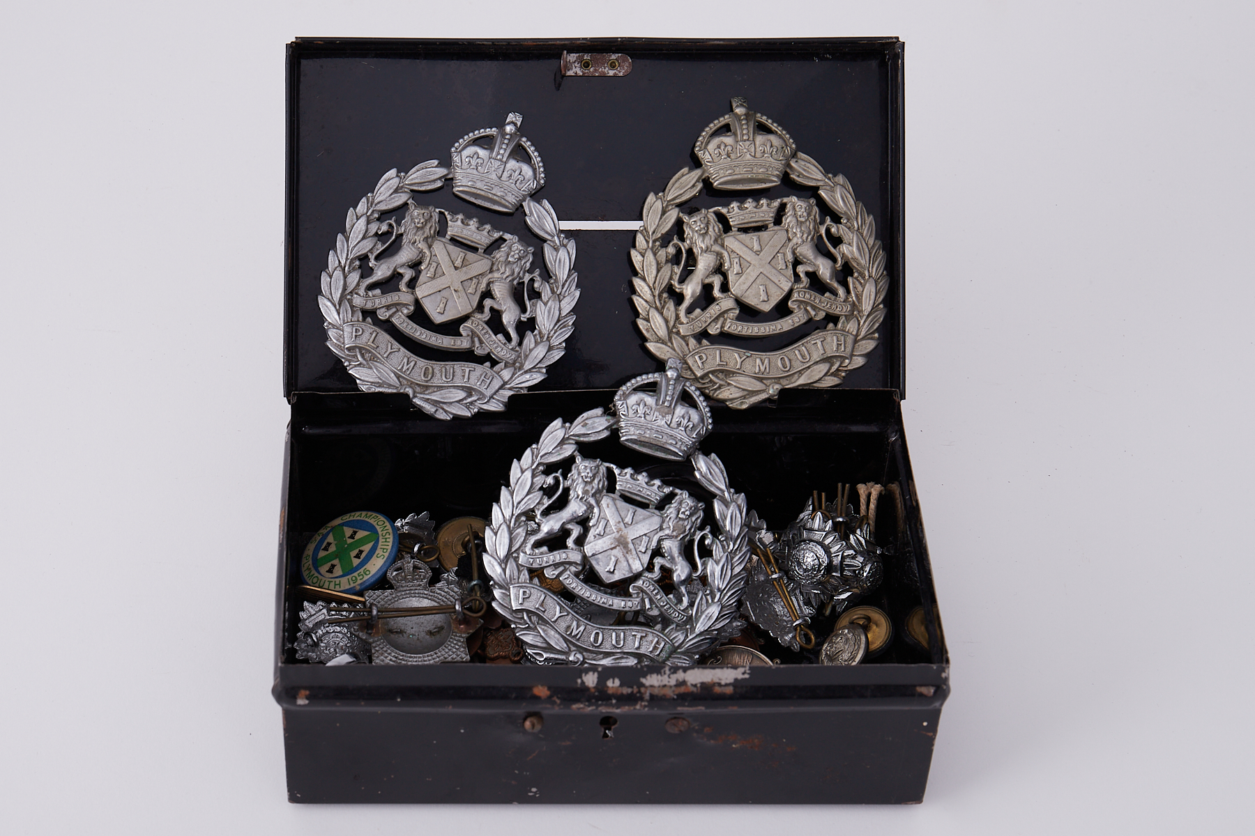 A selection of various military and other cap badges, pendants, including silver Devon Cadet Camp,
