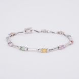 A white gold bracelet set with oval cut multi-coloured sapphires set in between small round