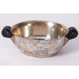An Arts & Crafts style silver hammered finish porringer with scroll design wooden handles, stamped