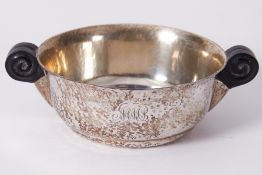 An Arts & Crafts style silver hammered finish porringer with scroll design wooden handles, stamped