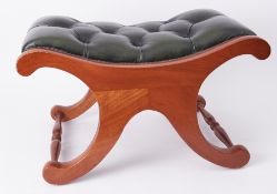 A reproduction foot stool with green leather upholstery.