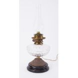 A squat Victorian oil lamp with clear glass reservoir and no shade.