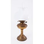 A small brass oil lamp with white shade.