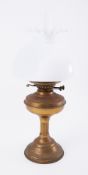 A small brass oil lamp with white shade.