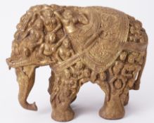 An Indian heavy and ornate brass Indian elephant, richly embossed with figures, height 29cm.