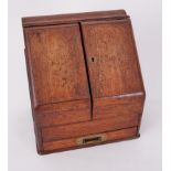 A Victorian oak stationary box fitted with various dividers and single drawer with a slope front,
