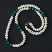 A string of freshwater pearls interspaced by malachite beads and gold roundels, strung to a 9ct