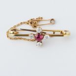 A yellow gold brooch set with a round cut ruby, approx. 0.35 carats and four old rose cut