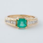 An 18ct yellow gold ring set with a central square cut emerald, approx. 1.16 carats, with five