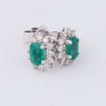 A pair of 18ct white gold oval cluster design stud earrings set with a central oval cut emerald,