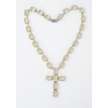 A large heavy silver cross pendant necklace set with rectangular cut yellow/green paste stones,