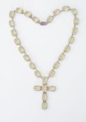 A large heavy silver cross pendant necklace set with rectangular cut yellow/green paste stones,