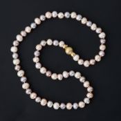 A string of natural shaped peach, pink & cream freshwater pearls strung to a frosted 18ct yellow