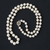 A 20" string of cultured pearls strung to a 9ct white gold flower design clasp (central pearl