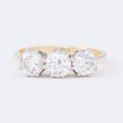 An 18ct yellow & white gold three stone ring set with three round brilliant cut diamonds, total