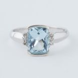 A 9ct white gold ring set with a rectangular cut blue topaz, approx. 2.60 carats, with three small