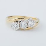 An 18ct yellow & white gold three stone twist ring set with three round brilliant cut diamonds,
