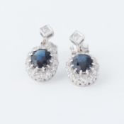 A pair of 18ct white gold cluster drop earrings set with oval cut sapphires, total sapphire weight