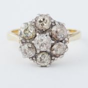 An 18ct yellow gold & platinum flower design ring set with old round cut diamonds, total diamond