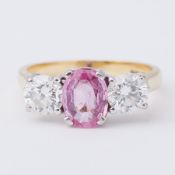 An impressive 18ct yellow & white gold three stone ring set centrally with an oval cut pink