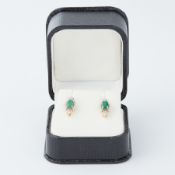 A pair of 18ct yellow gold marquise shaped stud earrings each set with an oval cut emerald, total