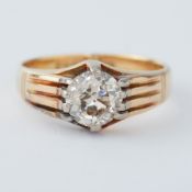 An 18ct yellow & white gold ring set with an old round cut diamond in a 'gypsy' style setting,