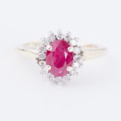 A 9ct yellow gold cluster ring set with a central oval cut ruby, approx. 0.75 carats, surrounded