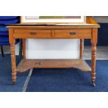 An Edwardian desk fitted with two drawers, on turned legs; used in the studio.
