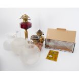 Victorian oil lamp with ruby glass reservoir and brass column together with two other oil lamps