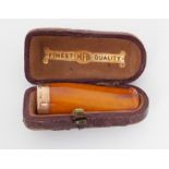 A cased 9ct gold nib and amber cheroot holder.