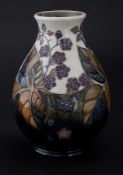 A Moorcroft vase, marked JK, berry's on pale green ground, height 19cm.