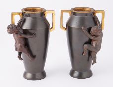 Pair of bronze continental vases each surmounted with a cherub, height 16cm.