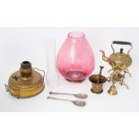 A large oil lamp with oval cranberry shade together with some brass wares.