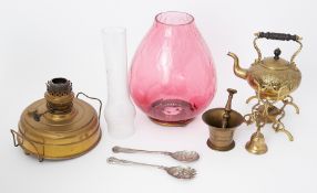 A large oil lamp with oval cranberry shade together with some brass wares.