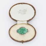 An 18ct white gold brooch set with oval carved piece of jade with leaf design, measuring approx. 2.